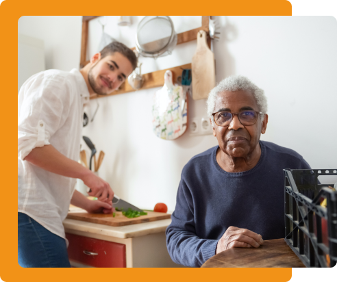 Jeune homme qui aide à la cuisine un homme âgé